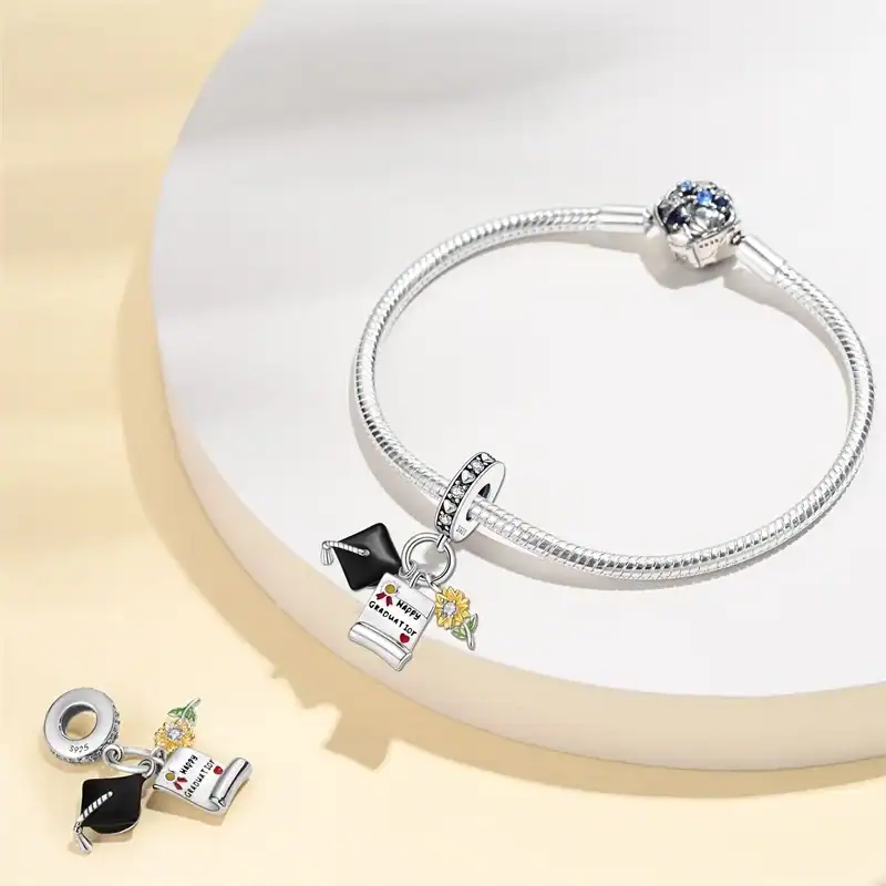 Bracciale e orecchini in argento con charms a forma di libro e fiore, gioielli eleganti e raffinati, perfetti per ogni occasione, disponibili su Polvere di Stelle Store.