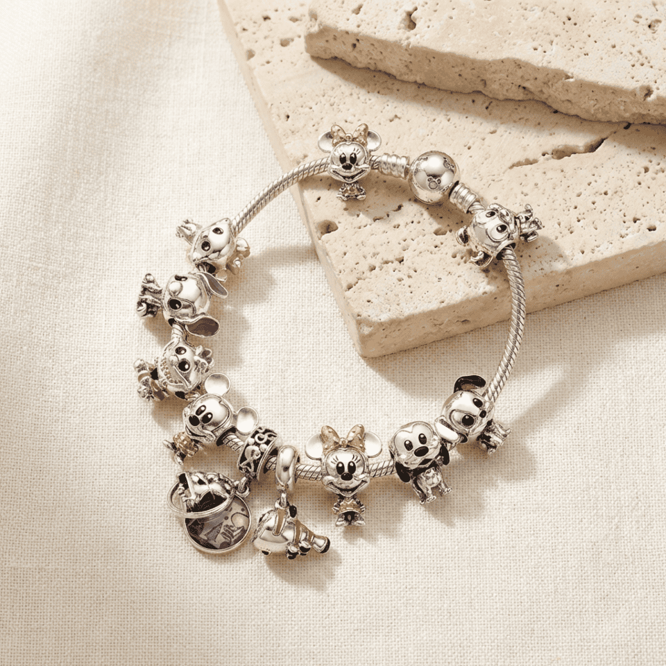 Bracciale charm in argento con personaggi Disney, perfetto come regalo originale e alla moda, ideale per gli amanti dei gioielli personalizzati e delle collezioni di accessori di tendenza.