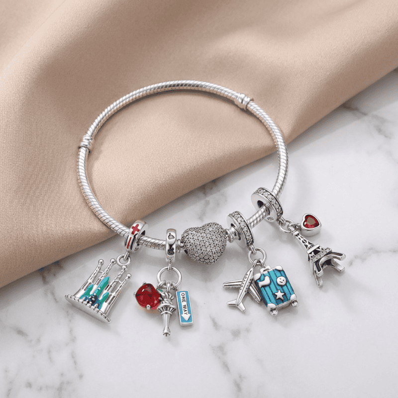 Bracciale charm con pendenti a forma di simboli di viaggio e amore, decorato con cristalli e charms colorati, ideale come regalo o accessorio di moda elegante.